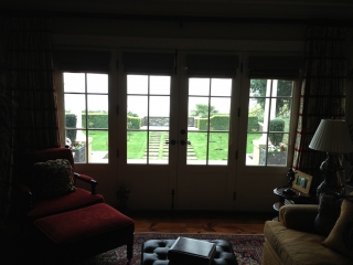 Interior picture looking out closed french doors to nice backyard