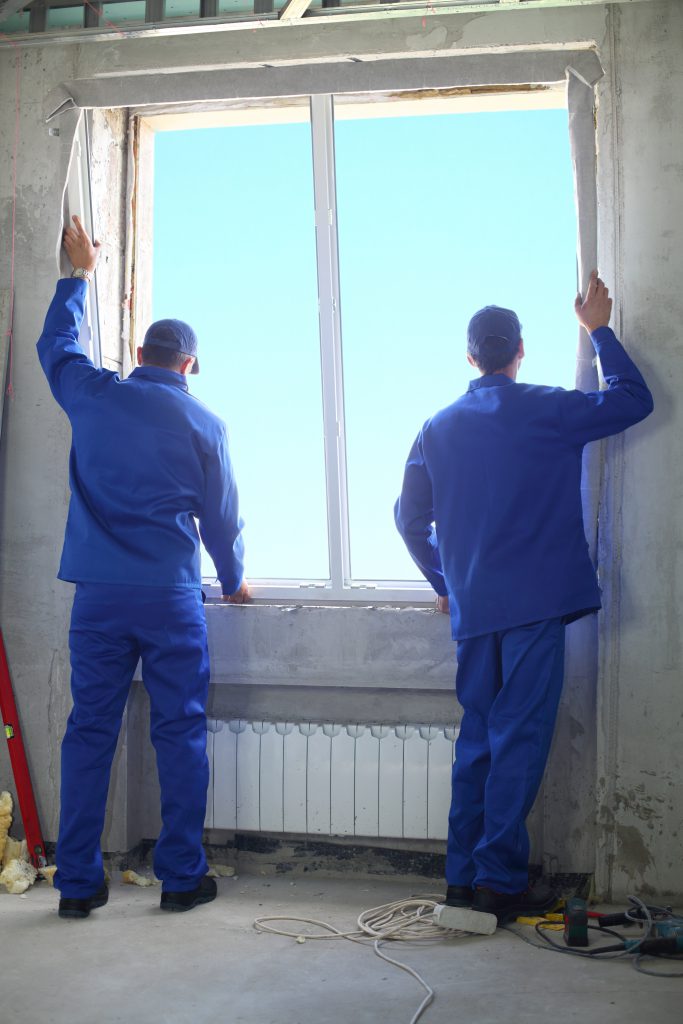 Window installers installing a solar control window